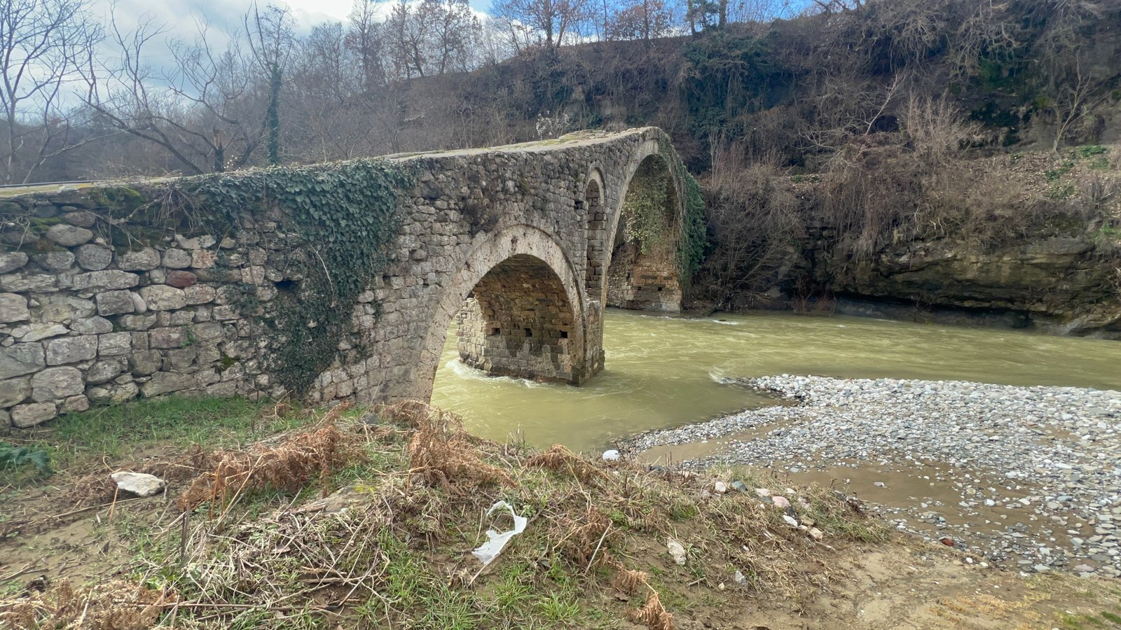 Ottoman-era Golik Bridge arching over a river near Pogradec, Albania